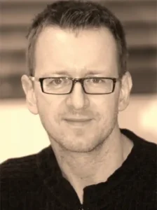 Portrait von Wolfgang Renje, Innenarchitekt, mit Brille und freundlichem Ausdruck.