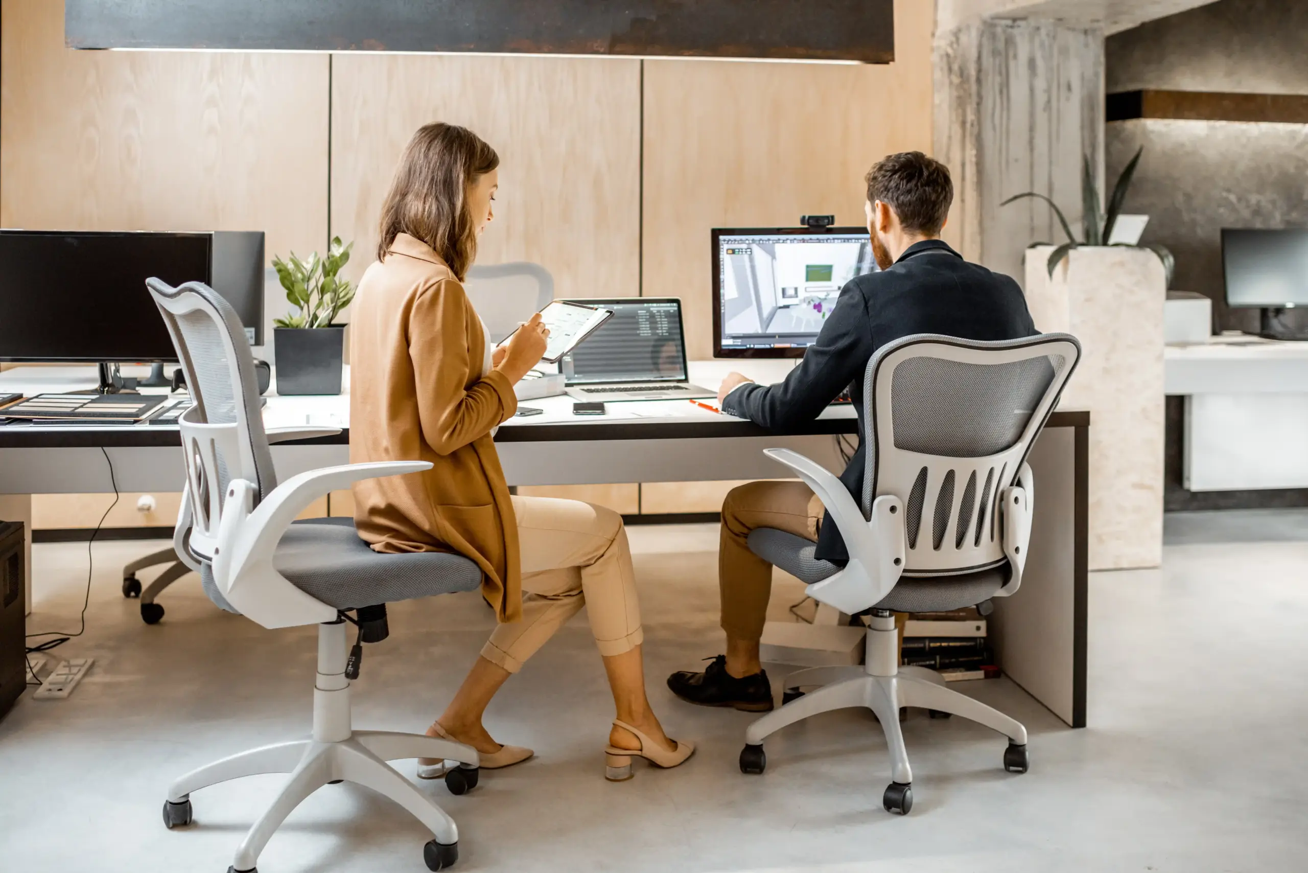 Zwei Innenarchitekt:innen arbeiten gemeinsam am Computer